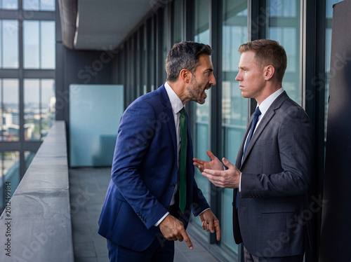 Fotografie Intense business dispute between two male colleagues in formal suits