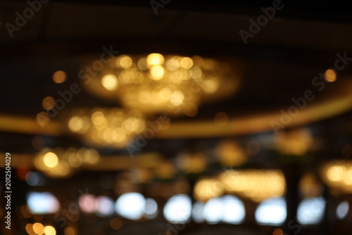 abstract blurred golden chandelier lights with bokeh effect in a luxury ballroom or hotel lobby background