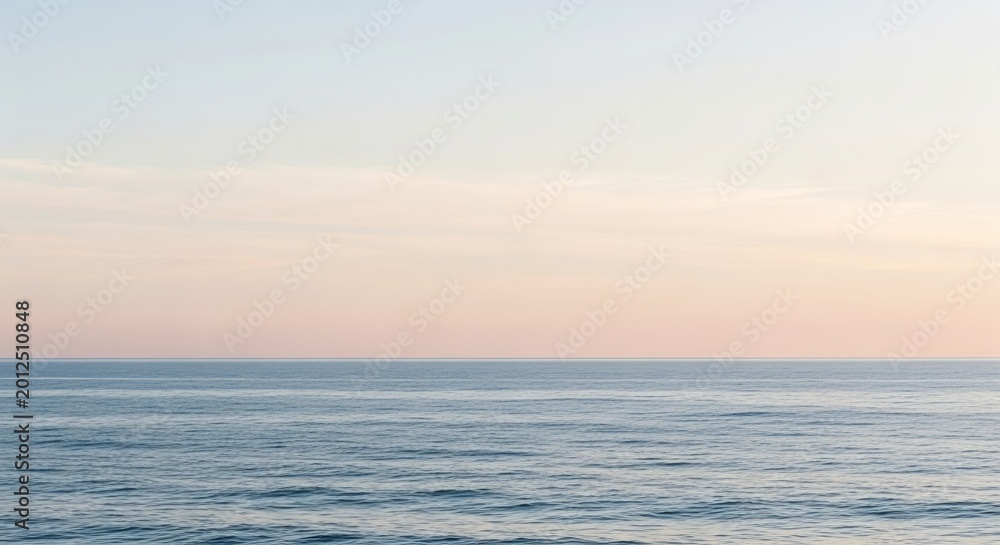 Fototapeta premium Calm ocean horizon with soft pastel sky at dawn or dusk, a serene natural landscape scene.