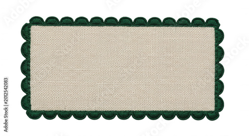 Rectangular beige linen fabric patch with a dark green scalloped crochet lace border isolated on a solid black background