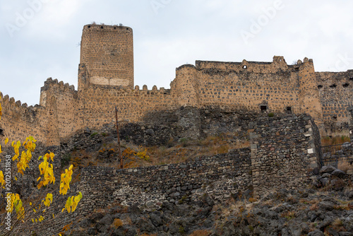 Old stone medieval castle on a steep cliff in Caucasus mountains in Georgia