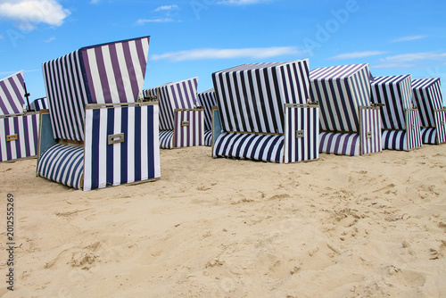 Vászonkép A row traditional striped beach chairs from the wind strandkotb on a sandy beach on the Baltic coast