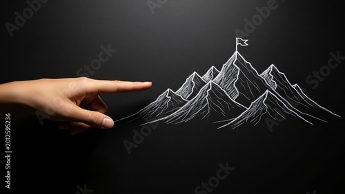 Creative hand pointing at chalk drawing of mountain peaks with a flag on the summit representing achievement success and adventure exploration on black background