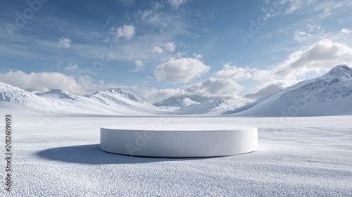A stark white podium sits on a snow-covered plain, backed by snow-capped mountains under a bright, cloudy sky