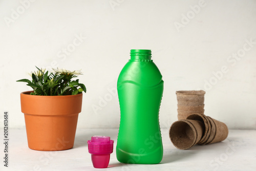 Tableau sur toile Bottle of plant fertilizer on light background