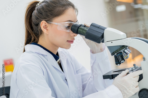 Scientist examines samples under microscope in laboratory during work hours