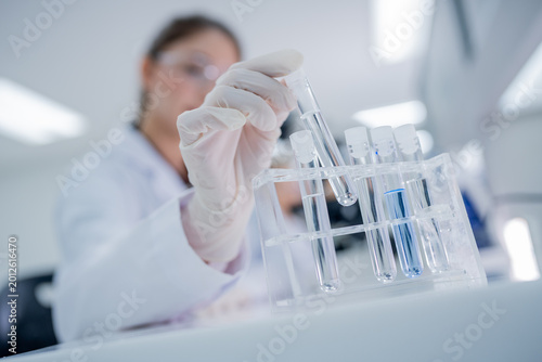 Scientist conducts experiment with test tubes in laboratory during daytime hours