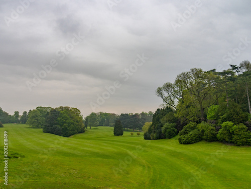 Scenic Golf Course with Rolling Green Fairways and Trees Under Overcast Sky