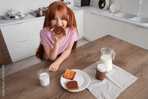 Cute girl eating toast with...