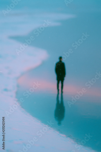 Lone Person Walking Through Misty Blue Shoreline
