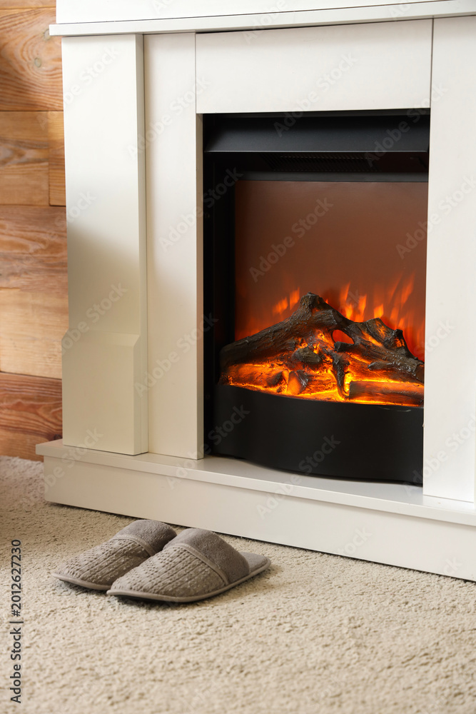 Fototapeta premium Slippers on soft carpet near fireplace in living room