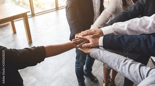 Foto Close-up of diverse business people stacking hands in a huddle, symbolizing strong teamwork and successful partnership