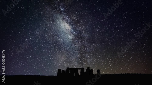 4K Astro time lapse of the stones of the ancient, prehistoric, summer solstice monument Stonehenge during night with the Milky way and thousands of stars, on Salisbury Plain in Wiltshire, England.