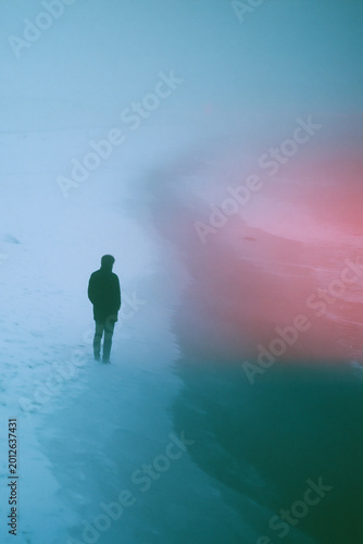 Vintage Film Photo of Man Standing on Snowy Coast with Grainy Texture, Faded Colors, 1980s Cinematic Look and Emotional Isolation