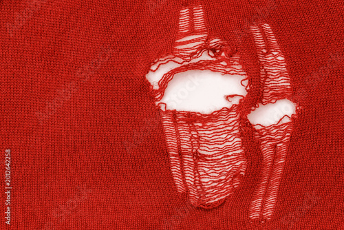 Obraz na plátně Red fabric with holes shows signs of wear and tear from everyday use over time