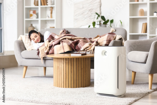 Fotografía Air purifier against woman sleeping on sofa at home