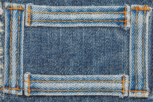 Obraz na plátne Fabric patch sewed on blue denim with yellow threads showing wear and texture de