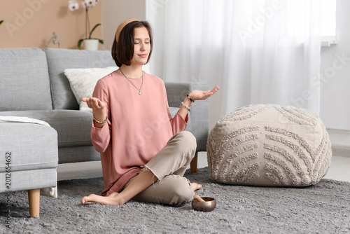 Young woman meditating whil...
