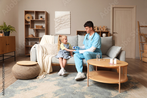 Male pediatrician measuring...