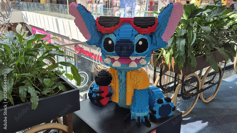 Fototapeta premium A large LEGO sculpture of Stitch wearing sunglasses and a yellow shirt, holding a microphone in a Park Lake shopping mall. Picture taken on May 7, 2026 in Bucharest, Romania.