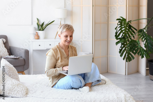 Mature woman using laptop i...