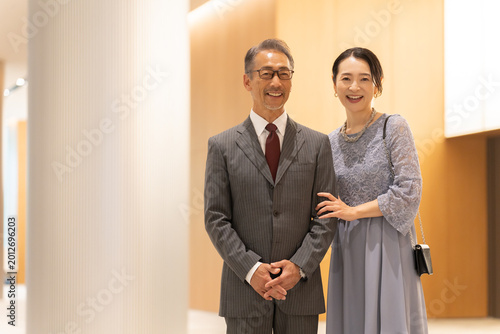 Fotografi ホールの前に立つフォーマルな中高年夫婦
