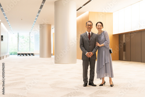 Billede på lærred ホールの前に立つフォーマルな中高年夫婦