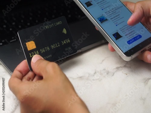 a person holding a credit card and opening e-commerce on a mobile phone
