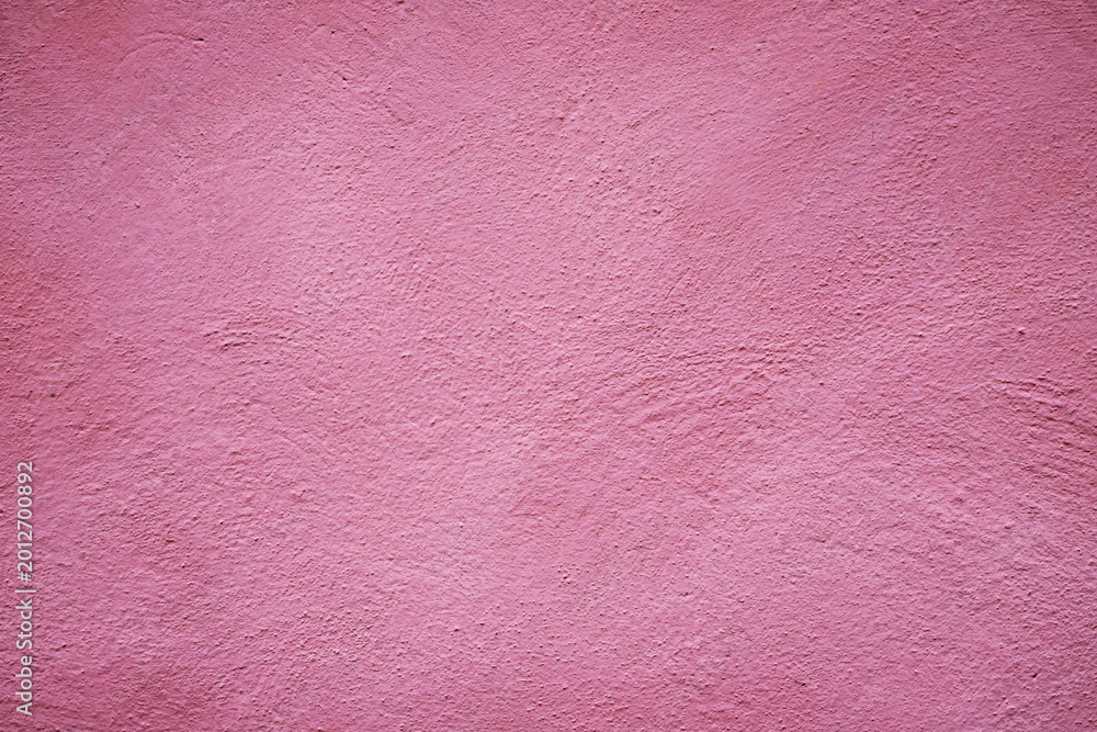 Fototapeta premium View of a textured pink wall showing small uneven patterns and a smooth surface in natural light during the day