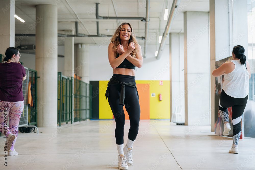 Obraz premium Women training together during energetic fitness class indoors