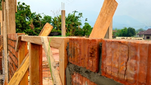Schilderij op canvas Brick Wall Construction with Wooden Formwork, Building Site in Progress