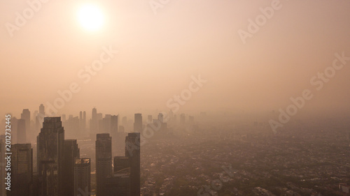 Aerial View of City Skyline Heavily Shrouded in Thick Smog and Air Pollution at Sunset