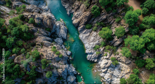 Aerial view of emerald river winding through rocky forest canyon; vivid natural style, symbolizing purity and wilderness, ideal for travel ads, eco branding, nature backgrounds and outdoor themes