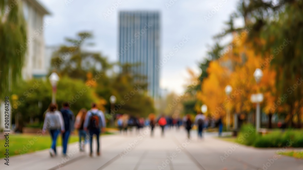 Obraz premium Blurred college campus walkway with students and academic atmosphere.