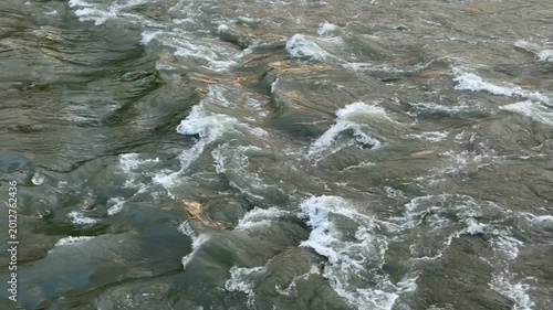 Close-up of rushing river water splashing on stones