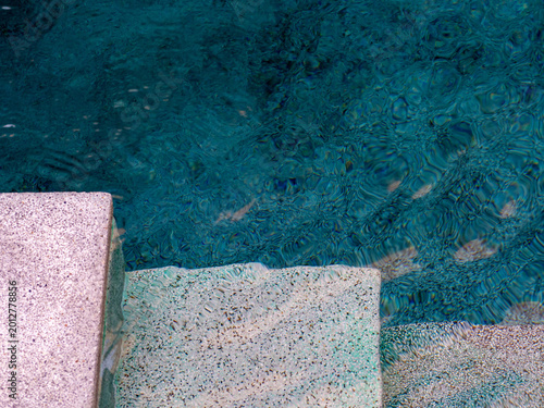 The edge of the pool and steps leading down to it are below, and the pool is submerged in crystal clear water