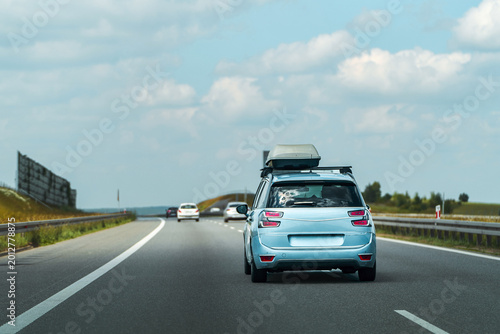 Vehicle moving on street with storage box for vacation