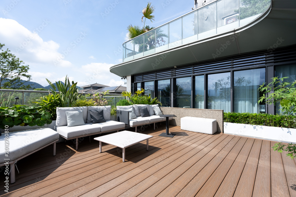 Fototapeta premium Modern high-rise terrace with wooden flooring and comfortable outdoor lounge area