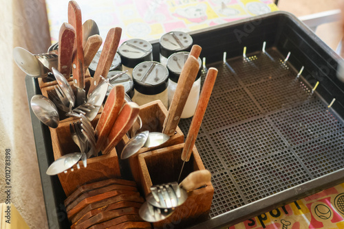 Foto Spoon fork cutlery in wooden holder on plastic tray kitchen utensil for dining f