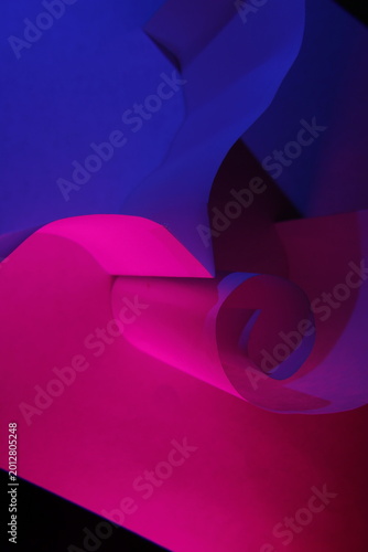 Fényképezés Composición abstracta de papel reciclado con líneas curvas y formas fluidas iluminadas con luces neón en tonos azul y magenta