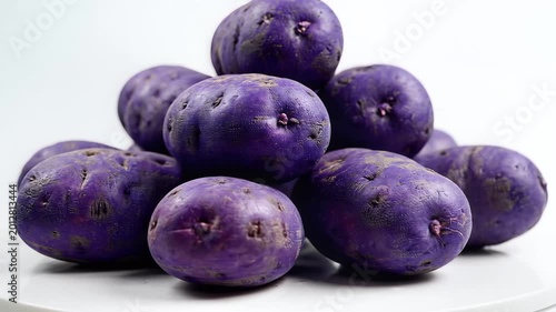 Pile of Vibrant Purple Potatoes on a White Surface.