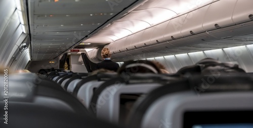 Interior of an aircraft, stewardess, rows of seats in an aircraft