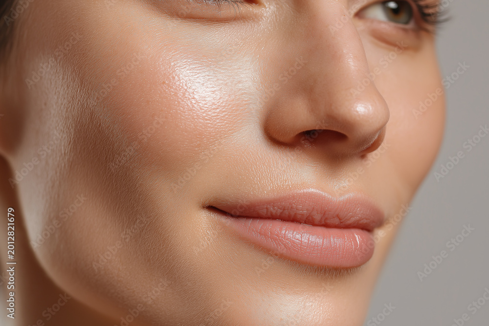Fototapeta premium Glowing dewy skin close up with gentle moisture layer on cheek and smooth natural lips conveying healthy hydrated complexion