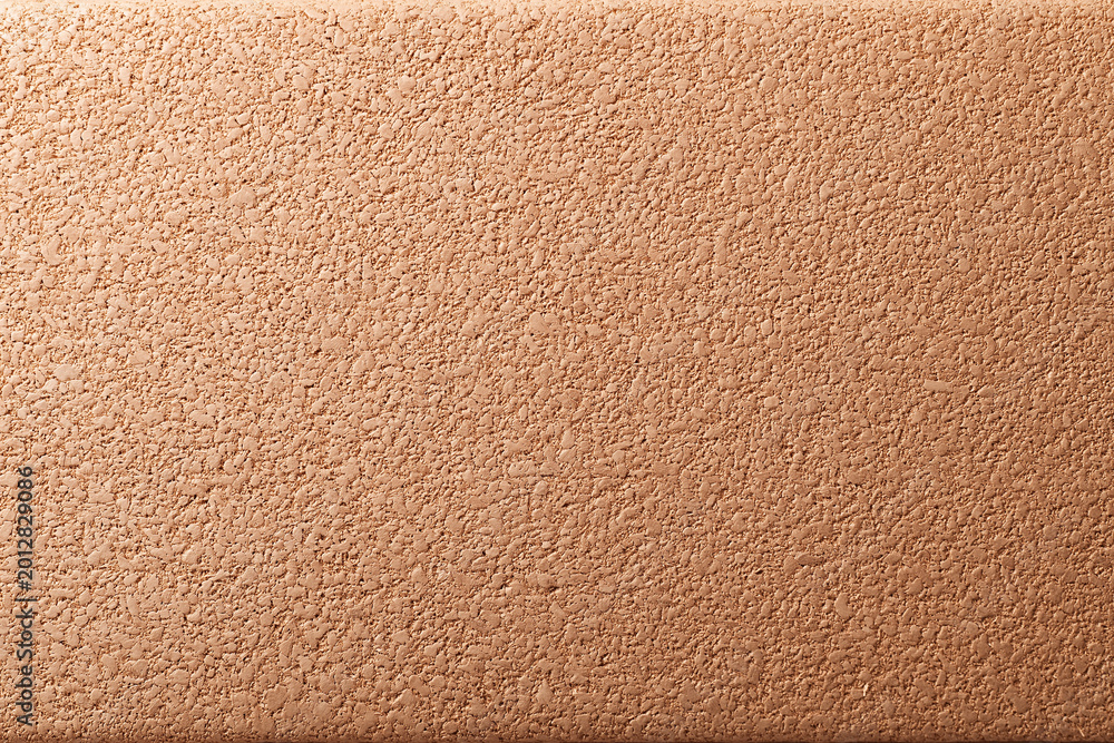 Fototapeta premium Warm brown cork wall texture with fine grain detail and subtle lighting creating natural organic pattern and warm atmosphere