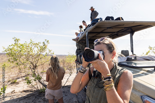 woman photographing on safari, Makgadikgadi Park, Botswana, Africa