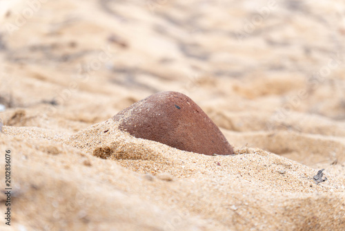 Konstfotografi Stones half buried in yellow sand texture