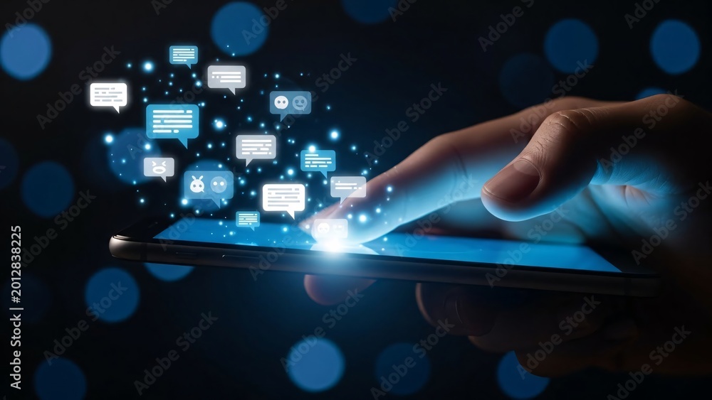 Fototapeta premium Close-up of a person's hand using a smartphone with floating digital chat icons and notifications representing communication technology and social media connectivity in a futuristic setting