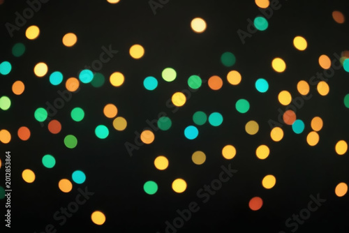 Colorful bokeh lights scattered against a dark background during nighttime celebrations