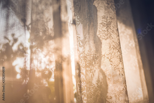 Warm Morning Sunlight Filtering Through Delicate Lattice Curtains