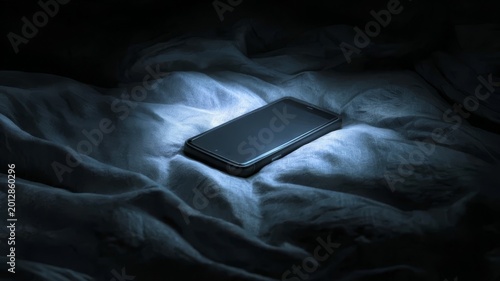 Dark phone rests on rumpled bed sheets